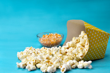 popcorn falling from paper packaging with blue background