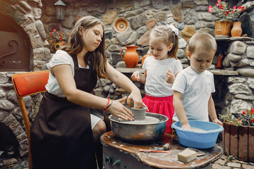 Children make a small jug. Hands of a potter at work