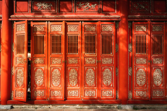 Oriental red monument in Imperial City, Hue. Famous gallery behind tall grass moving by wind breeze. Ruins in  Citadel famous landmark of Vietnam.