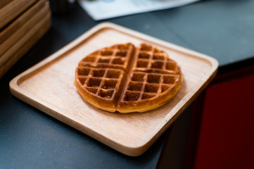 waffles with butter on wooden plate