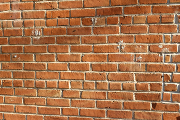 Obraz premium Deteriorating old red clay brick wall texture with stray shadows (angle view)