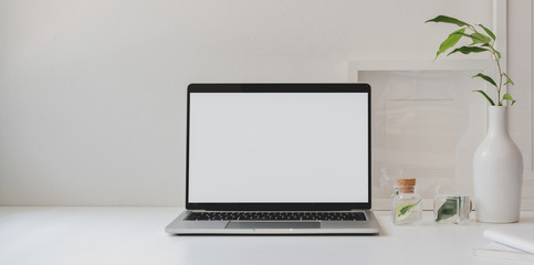 Fototapeta premium Mock up laptop computer in minimal workspace with copy space and ceramic vase