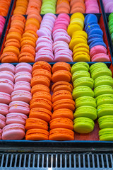 Closeup photo of pile of multicolored macaroon cakes at bakery 