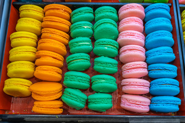 Lovely and multicolored macaroon cakes in tray at bakeshop