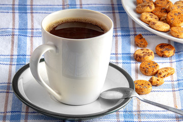 Cup of coffee and croissant on wooden table