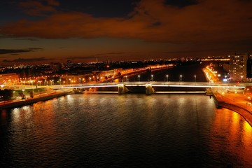 Fototapeta na wymiar Panorama of the night city.River bridge.Photos from the drone.
