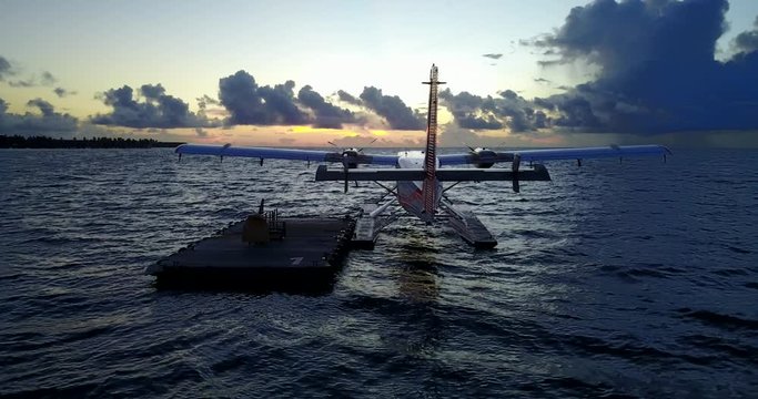 Hydroplane waiting near a wooden platform floating on shore water at cloudy sunset in Fuga island