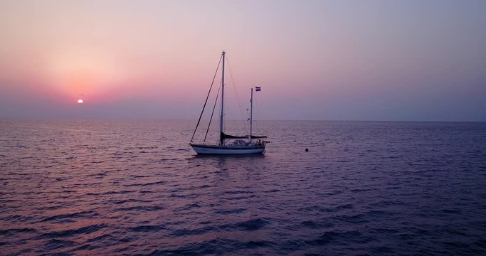 Cinematic seascape on purple colors of sunset, focusing a sailing boat in the middle of ocean, Thailand