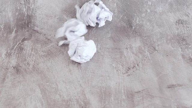 creative block concept, scrunched paper balls thrown into the scene and one idea lightbulb rolling among them