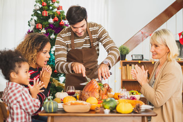 Happy Thanksgiving dinner party with family and food with turkey on table