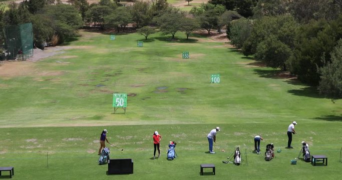 People practicing the golf swing at a golf range