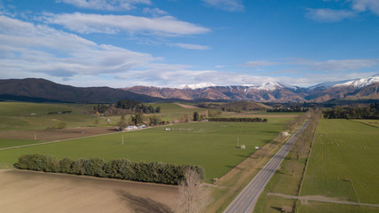 Amazing aerial view of green field with snowcap mountain in background.Aerial Panoramic view of Mount Cook in New Zealand.