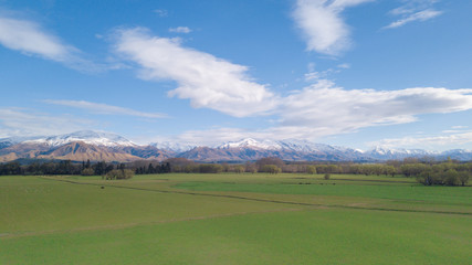 Amazing aerial view of green field with snowcap mountain in background.Aerial Panoramic view of Mount Cook in New Zealand.