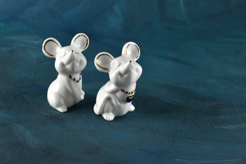 Porcelain mouses on a blue background. Symbol of 2020 year white metal rat.