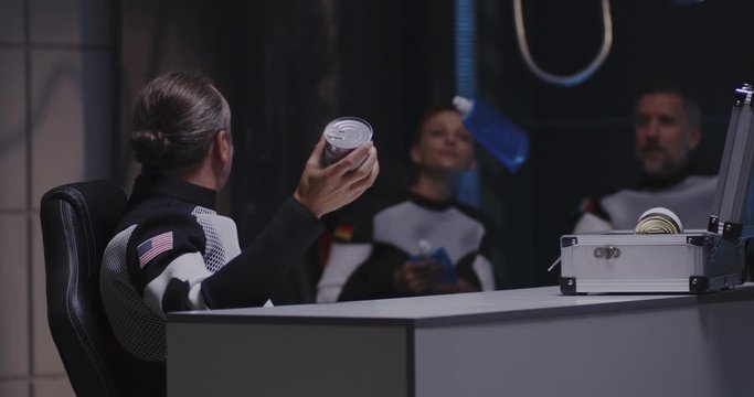 Astronaut catching tin can in zero gravity