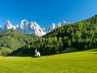 Famous St Johann Church and Odle Mountain peaks in the background. Santa Maddalena, South Tyrol, Italy. September 2017