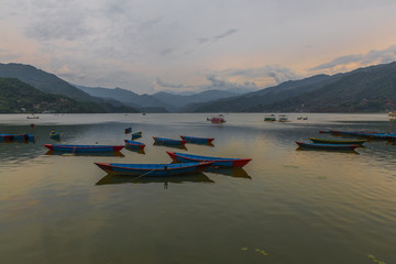 Fototapeta na wymiar colorful boats in Fewa lake after the storm in Pokhara, Nepal