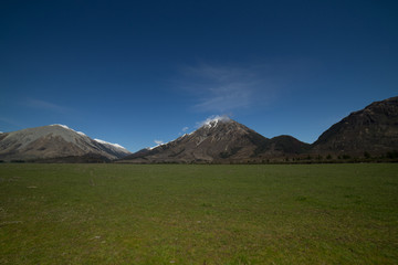 Beautiful scenery of snowcap mountain with green dairy farm in Arthur's Pass,New Zealand.