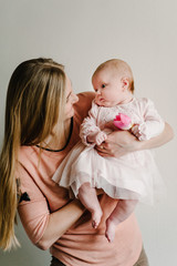 A little girl gives Mom a flower of pink tulip in honor of the women's day on March 8 and the mother's day. New life, love, holiday concept.