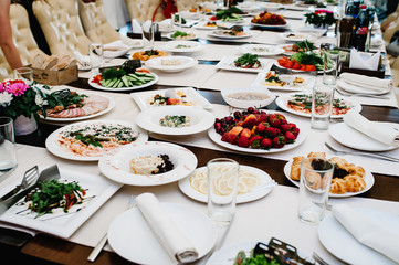 Served table with food. Plates with dishes on the table. The beginning of the holiday. Festive table in the restaurant. Side view.