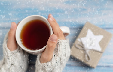 Obraz na płótnie Canvas girl with hot tea under snowflakes. concept of a cozy winter tea party