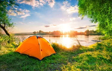 Fotobehang Orange tent on the lake at sunset © alexlukin