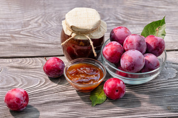 Plum jam in closed jar and saucer and plums