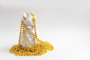 white pineapple in gold Christmas beads. alternative Christmas tree. minimal creative concept. 