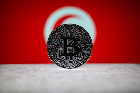 Physical silver version of Bitcoin (BTC) and Tunisia Flag on the background. Conceptual image for investors in cryptocurrency and Blockchain Technology.