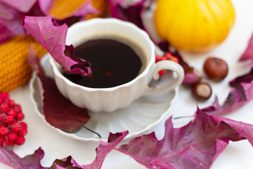 Autumn coffee time. Autumn leaves, pumpkins and berries on white table. 