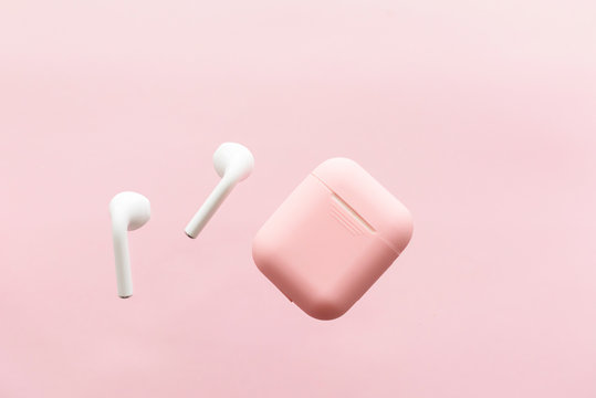 wireless headphones and pink case on pink background