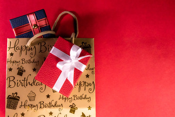 Birthday gift concept. Top view of red and blue gift boxes and carry bag with birthday initials on...