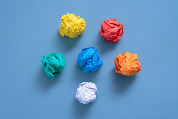 Crumpled colorful paper pages on blue background.