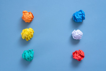 Crumpled colorful paper pages on blue background.