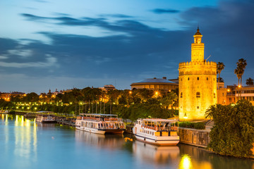 The Golden Tower (Torre del Oro) in Seville, Spain, is located at the margin of the Guadalquivir river and was built in the XIII century by the muslims ruling the area at the time. - obrazy, fototapety, plakaty