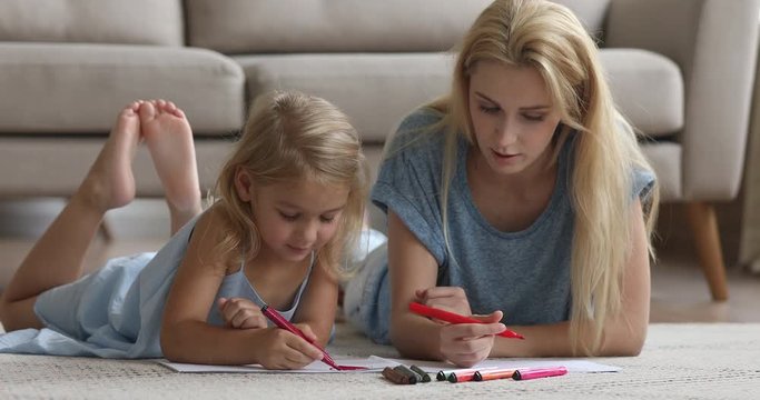 Cute child daughter drawing with felt pen play with mom