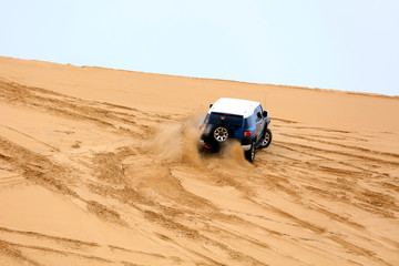 Fototapeta na wymiar Off-road vehicle traveling in the desert