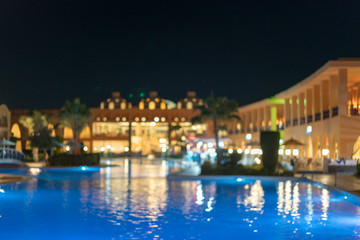 Fototapeta na wymiar Huge nightly hotel with pool. Blurry
