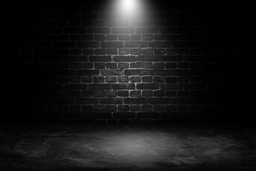 Abstract image of Spot lighting with black brick wall in background. - obrazy, fototapety, plakaty