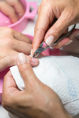 Close up woman hand while process of manicure in nail shop. Beautiful concept. female nail manicure processing. vertical photo