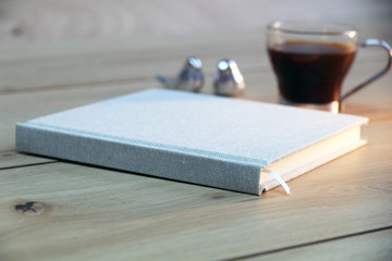 notebook on wooden table with pen and coffee