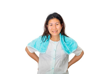 An Asian woman in blue pajamas is standing in studio with one small blue towel over her shoulder.