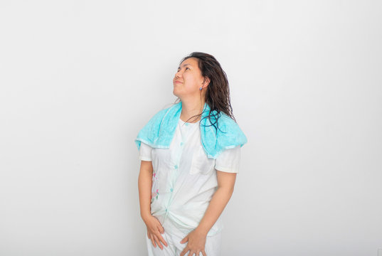 An Asian girl in blue pajamas is looking up  and smiling to the blank space over her head.