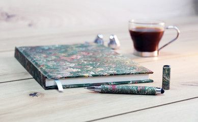 notebook on wooden  table with pen and coffee