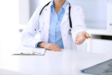 Doctor woman showing helping hand. Perfect medical service in clinic. Happy future in medicine and healthcare