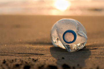 Transparent plastic bottle abandoned on mediterranean spanish beach (Guardamar del segura), sea on background