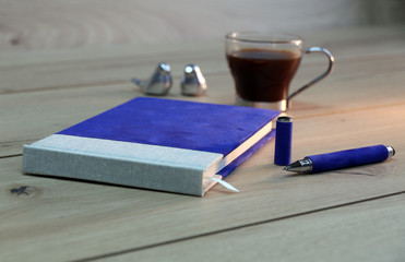notebook on wooden  table with pen and coffee