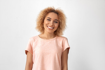 Freestyle. Young woman standing isolated on grey smiling cheerful close-up