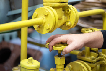 Engineer opens a water valve of pipeline close up.