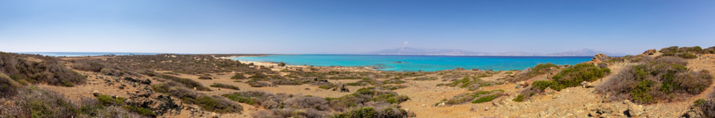 Fototapeta na wymiar amazing panorama from a desert to a nice gulf , beach , rocks and deep azure sea and high mountains and blue sky on the background. Greek landscape.